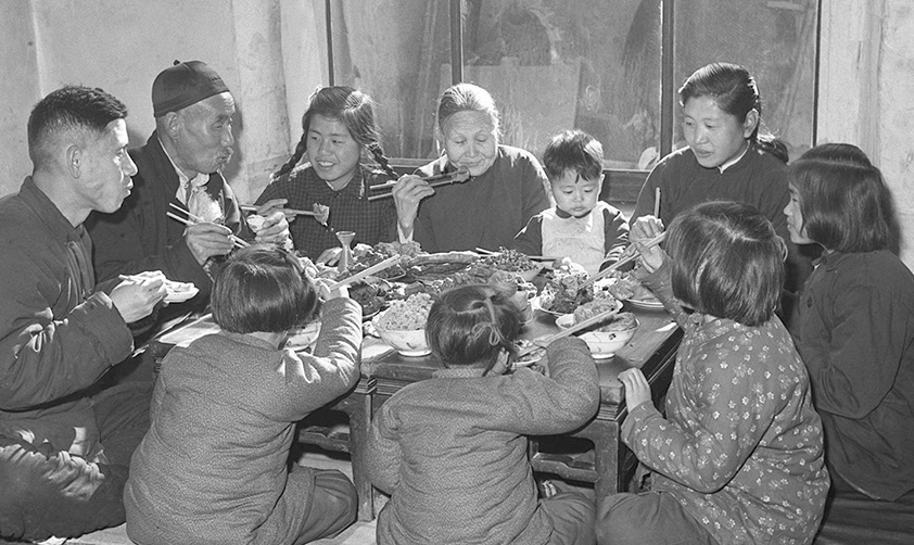 1953年春節(jié)天津漢沽區(qū)蘆臺王德鑄(左一)一家人吃團圓飯(新華社稿)